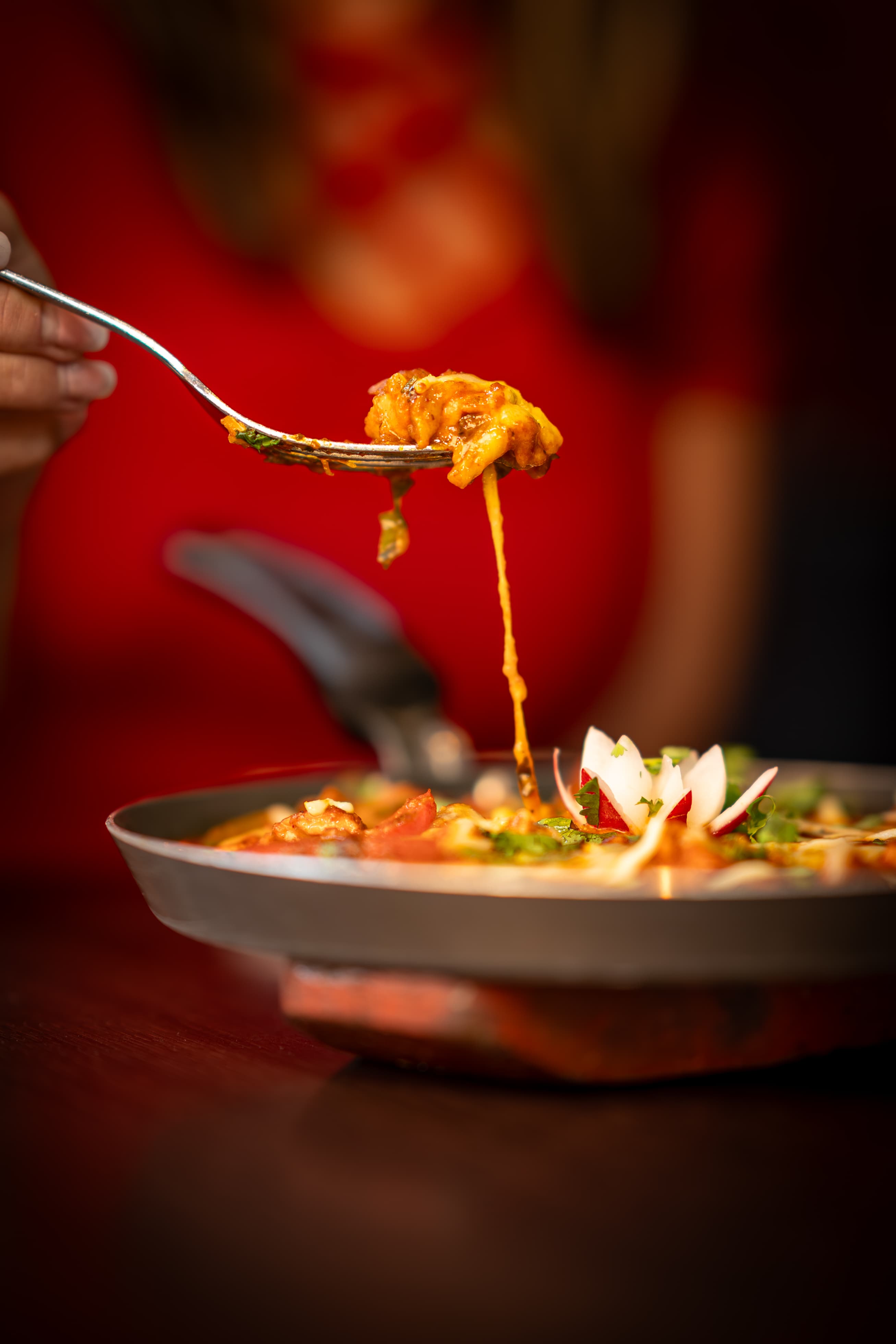 Fork lifting curry with melted cheese