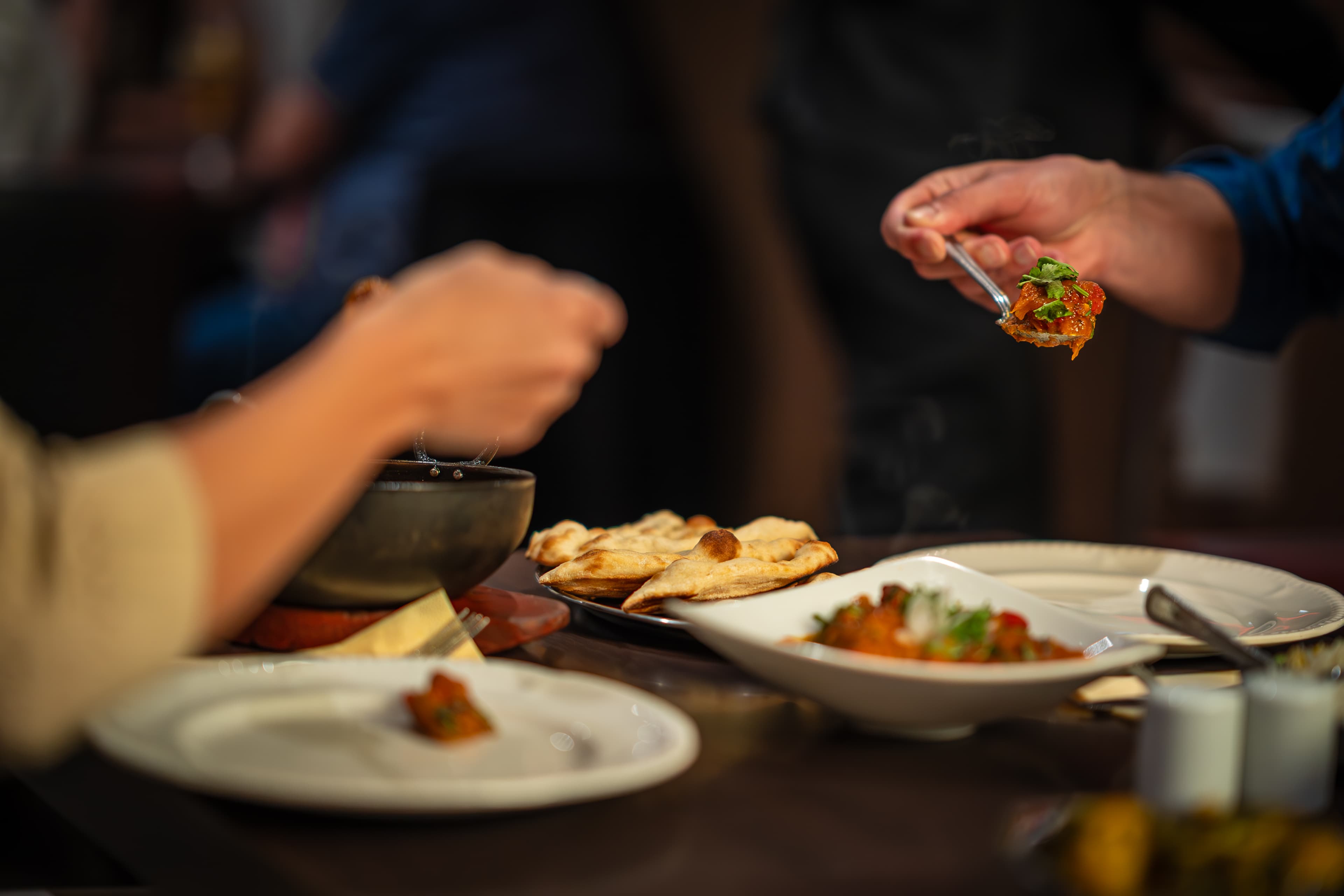 Table spread with curry, naan, and karahi dishes
