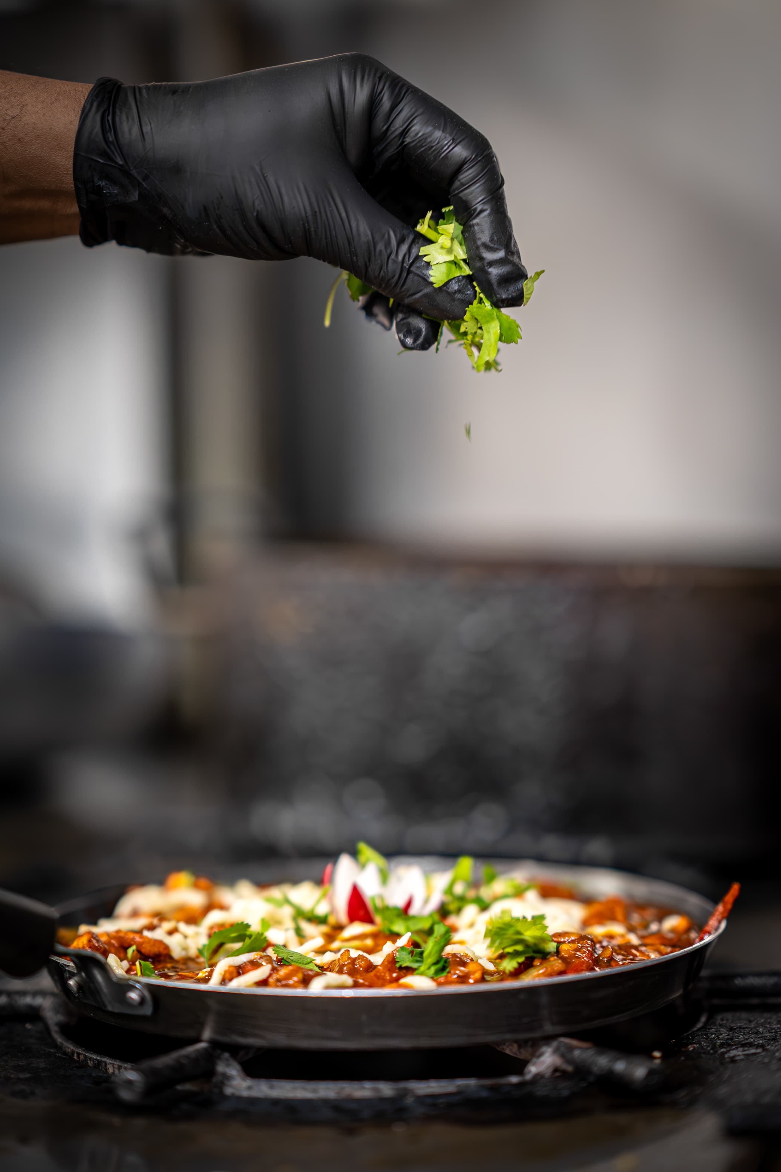 Coriander being sprinkled over a curry