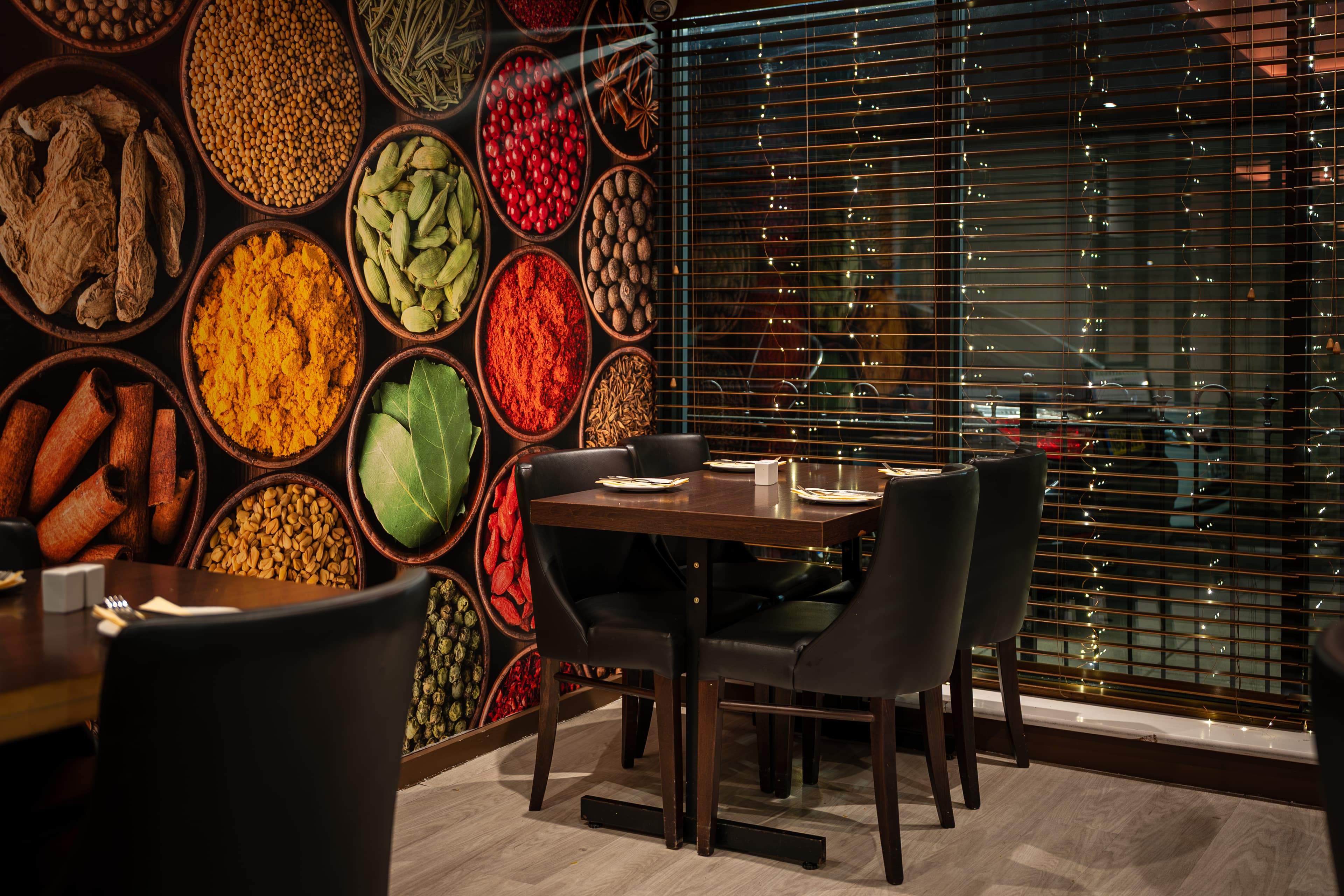 Table set beneath a spice collage mural