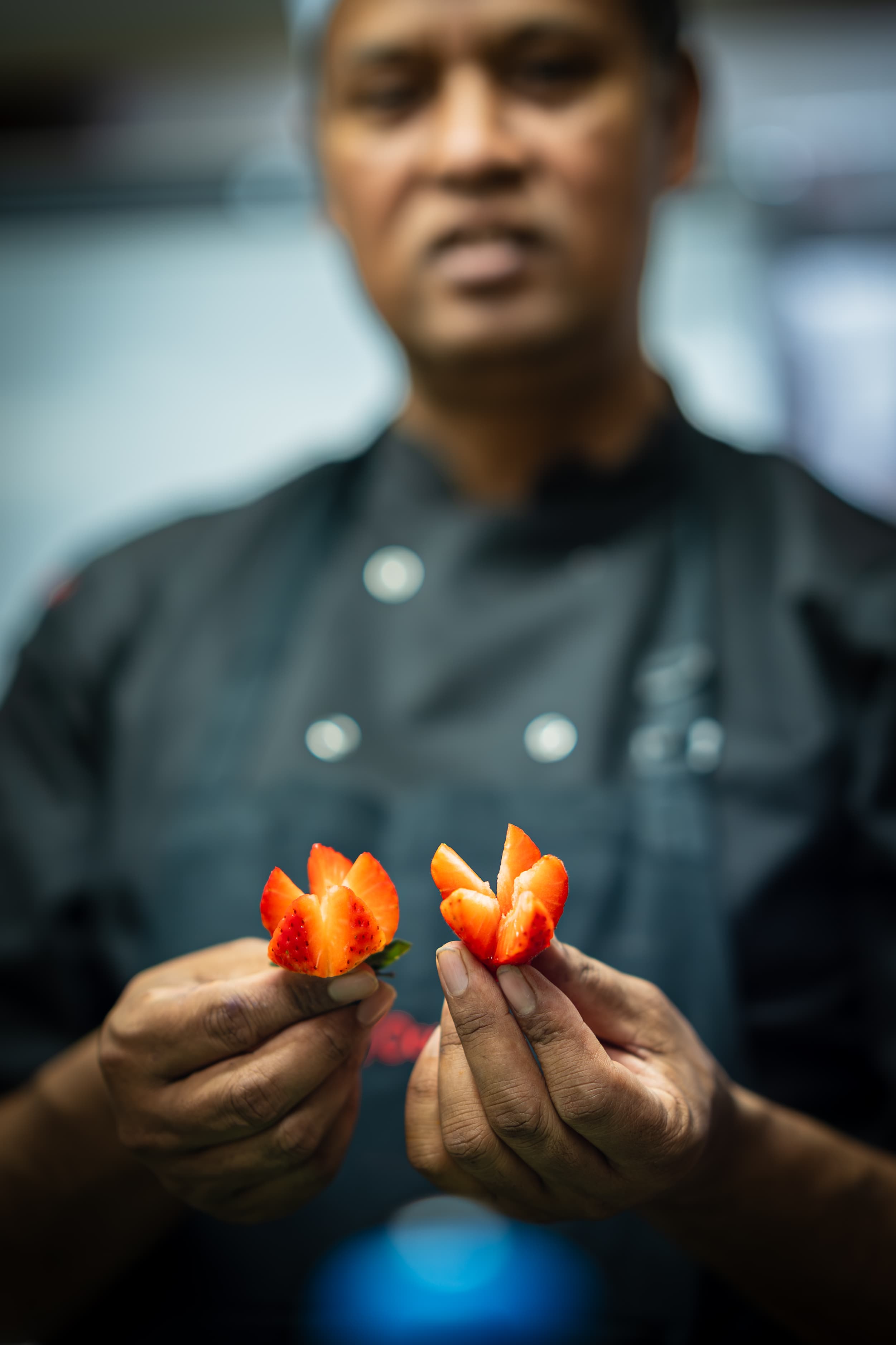 Chef presenting carved strawberry garnishes