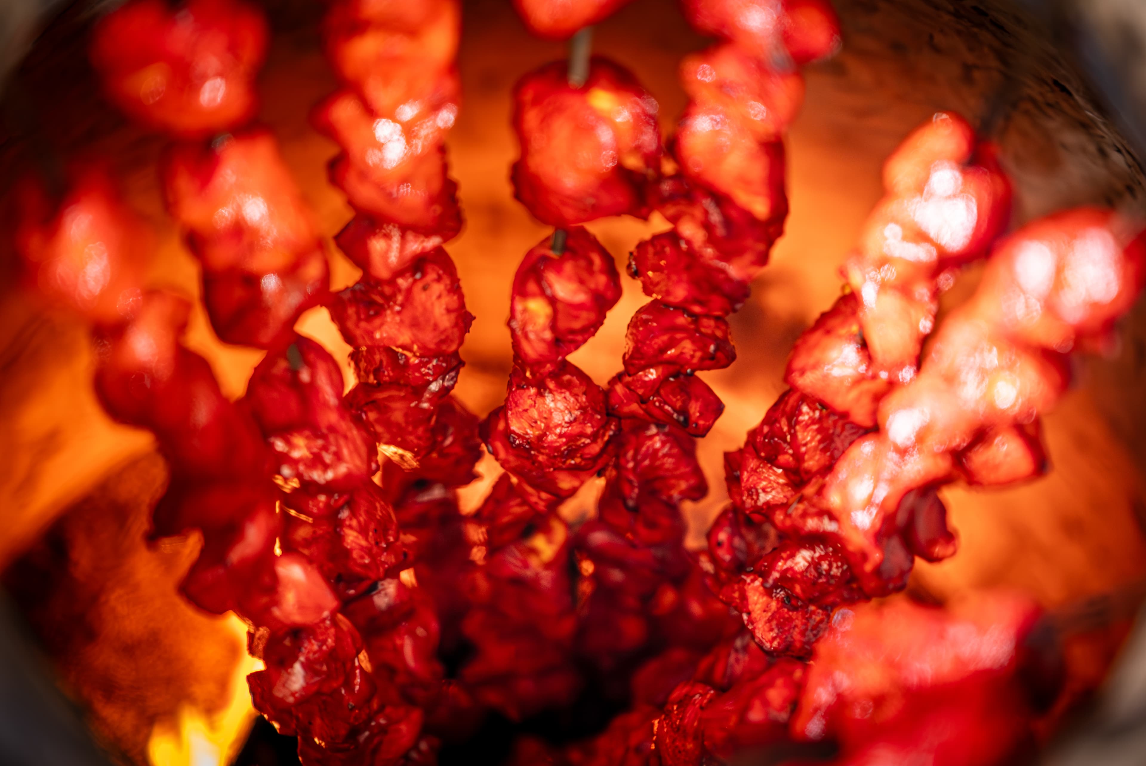 Marinated skewers cooking over flames in the tandoor at Indian Ocean